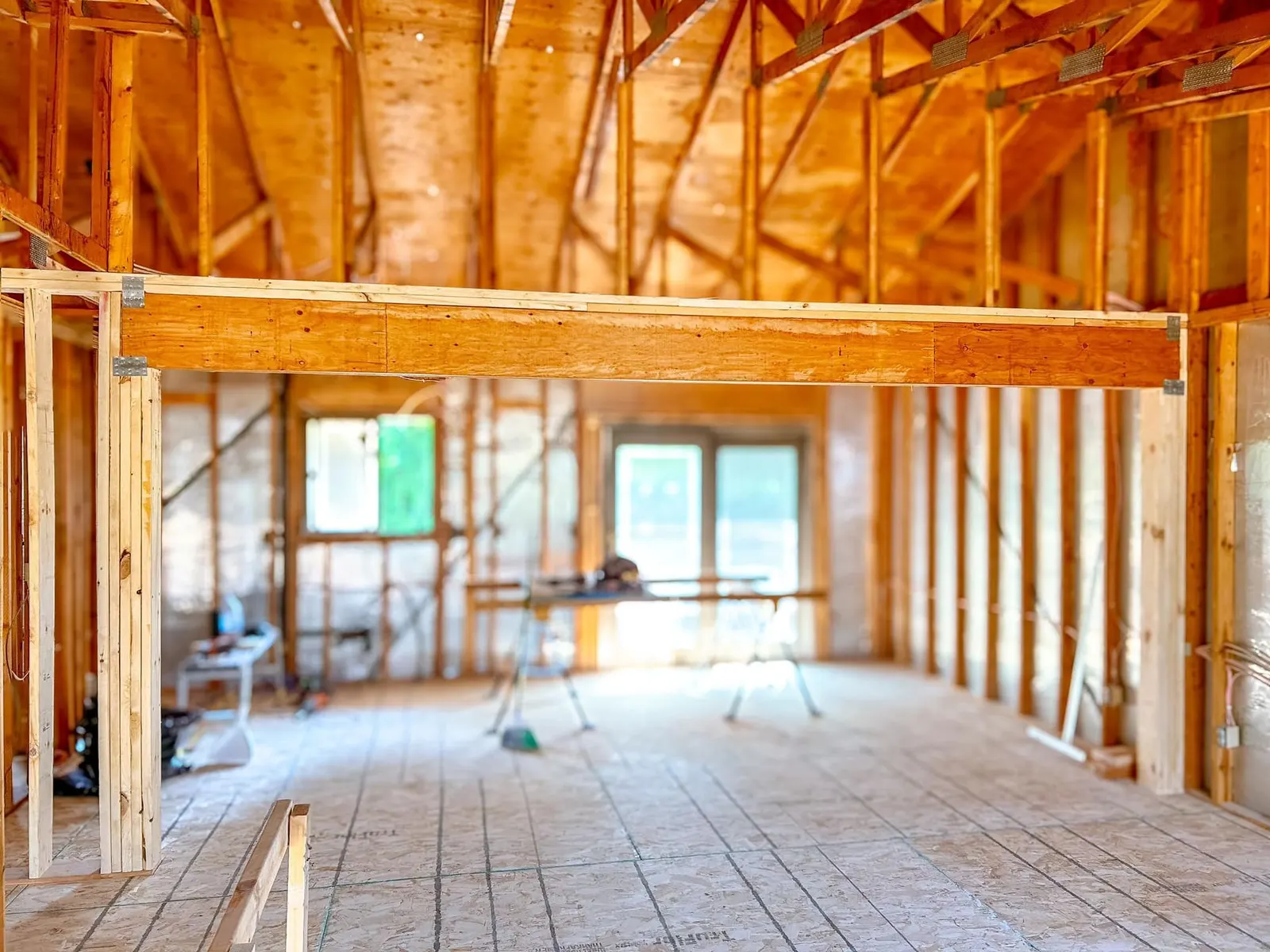 Interior of a house under construction with open wood framing and window openings