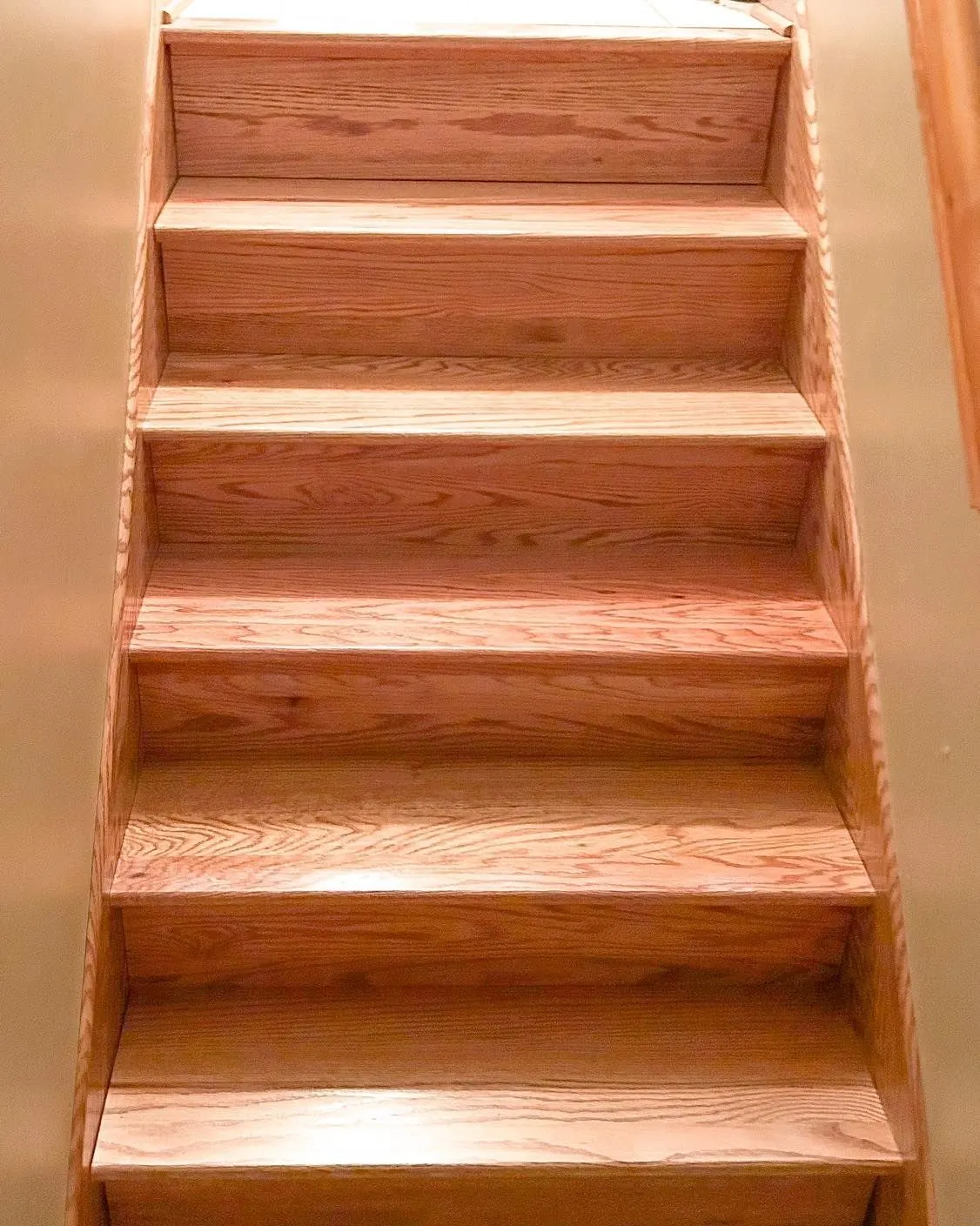 New oak staircase with stained treads viewed from the bottom landing