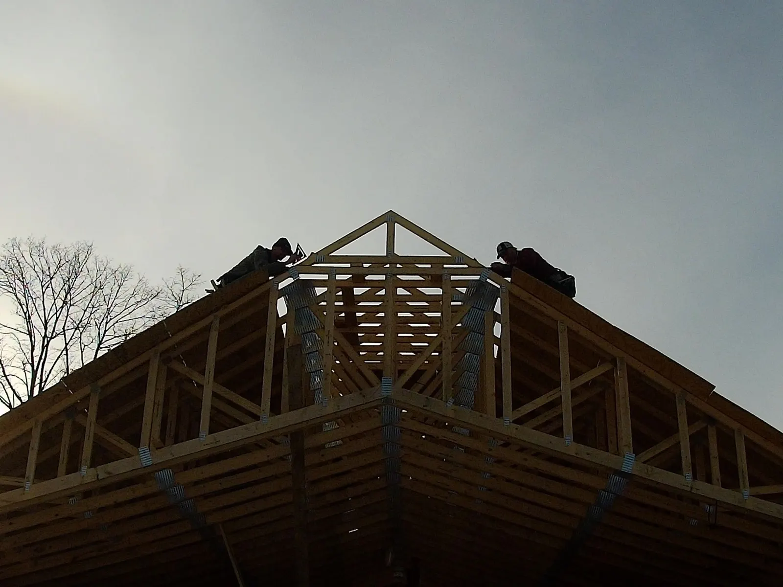 Wood roof trusses on a new addition against a gray sky